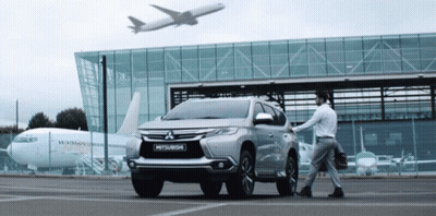 Mitsubishi SUV With Airplane Flying Overhead GIF