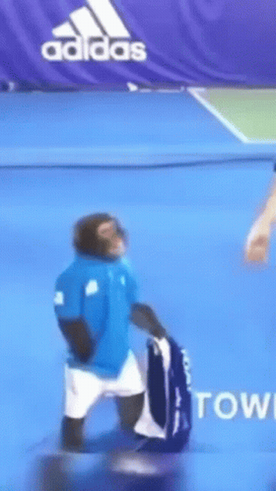 Monkey In Blue Shirt Holding Tennis Racket GIF