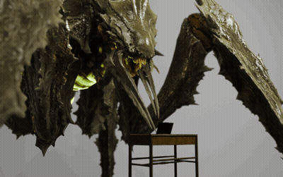 Monster Statue Standing Beside Desk With Laptop GIF