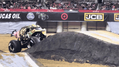 Monster Truck Driving Down Dirt Track In Front Of JCB Sign GIF