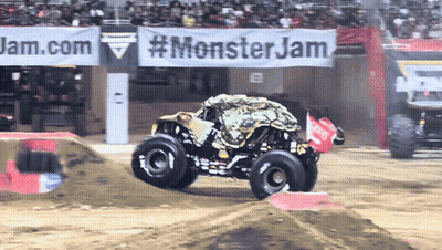 Monster Truck Driving Down Dirt Track In Front Of Monster Jam Banner GIF