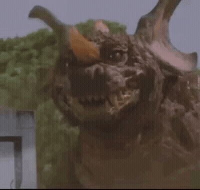 Monster With Horns Looking At Camera In Trees GIF