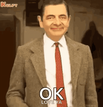 Mr Bean In Suit And Tie Smiling Saying Ok Love Ya GIF