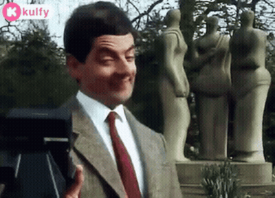 Mr Bean Is Making A Funny Face While Standing In Front Of A Camera . GIF