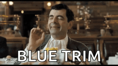 Mr Bean Is Sitting At A Table With A Napkin Around His Neck And Eating A Sandwich . GIF