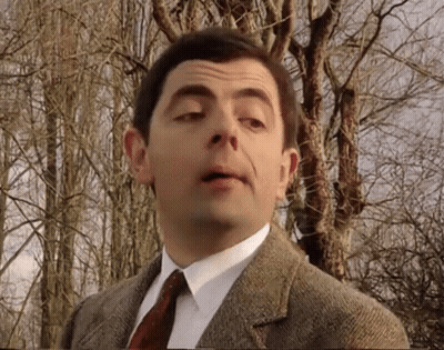 Mr Bean Is Wearing A Suit And Tie And Making A Funny Face . GIF