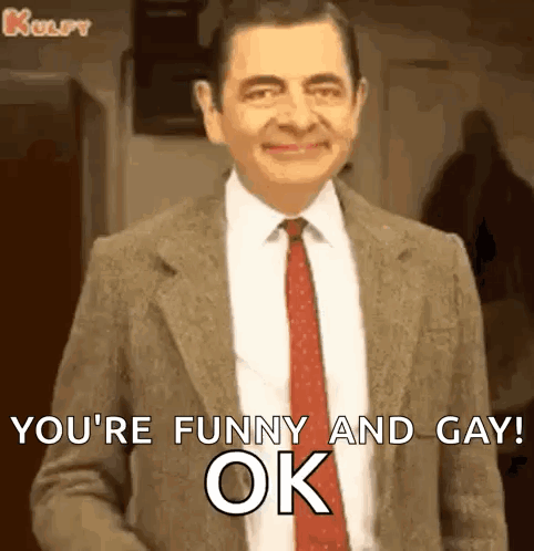 Mr Bean Is Wearing A Suit And Tie And Smiling While Saying `` You 'Re Funny And Gay Ok '' . GIF