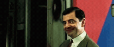 Mr Bean Smiling By Red And Blue Wall GIF
