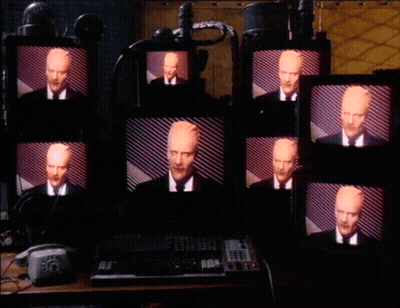 Multiple Monitors With Man In Suit GIF