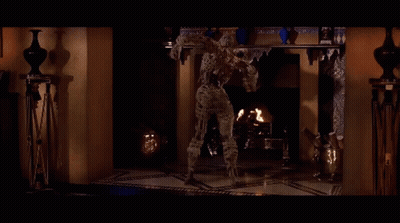 Mummy In Front Of Shelf With Vases GIF
