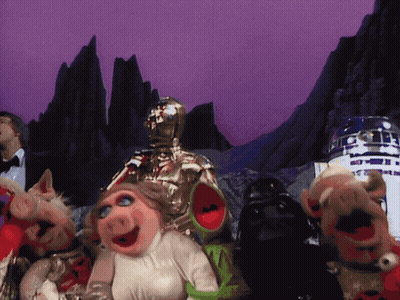 Muppets Standing in Front of Man in Tuxedo