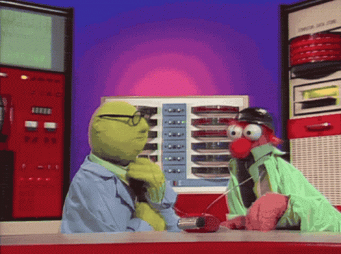 Muppets Talking To Each Other In Front Of A Machine That Says ' A ' On It GIF