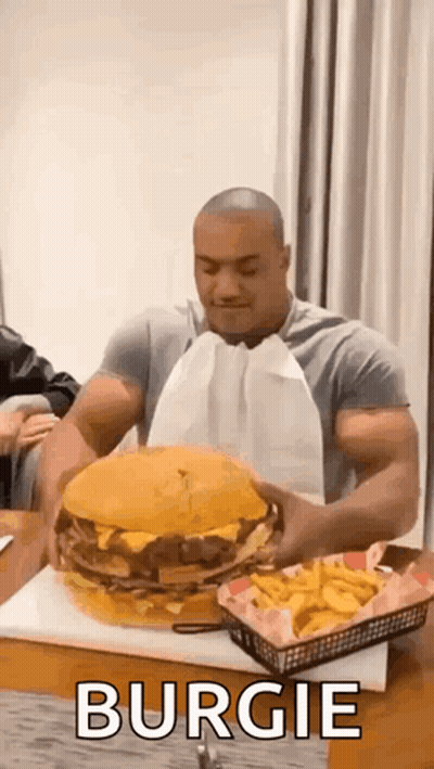 Muscular Man Eating Large Hamburger And French Fries GIF