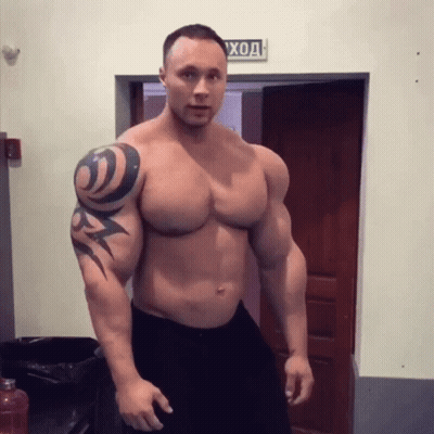 Muscular Man With Tattoo Standing In Front Of Door Saying Вход GIF
