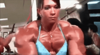 Muscular Woman In Blue Bikini Looking In Mirror At Gym GIF