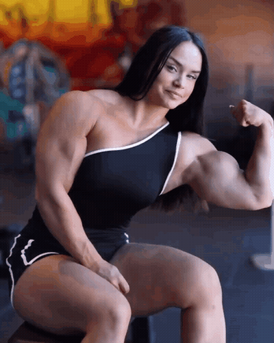 Muscular Woman Sitting And Flexing GIF