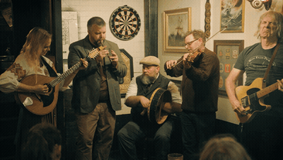 Musicians Playing In Room With Dart Board GIF