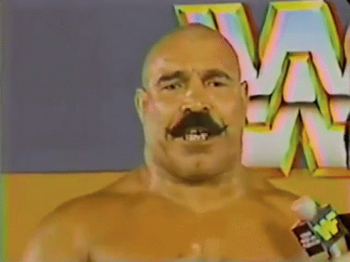 Mustached Man Holding Microphone In Front Of W Logo GIF
