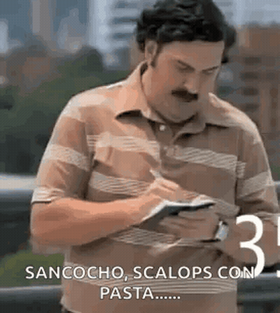 Mustached Man Writing Paper Looking at Phone