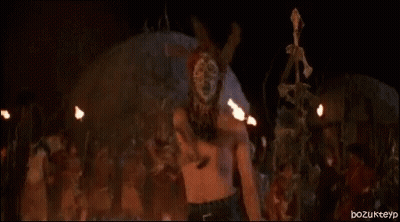 Naked Woman Standing In Front Of Fire In Dark Room GIF