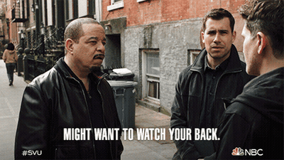 NBC Ad Three Men Talking On Street Saying Might Want To Watch Your Back GIF