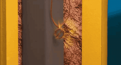 Necklace With Ring Hanging From Yellow Wall GIF