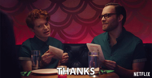 Netflix Ad With Two Men Sitting At Table Holding Menus GIF