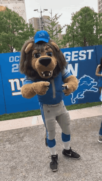 New York Giants Mascot In Front Of Blue Fence GIF