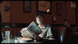 Nic Cage Reading Book In Diner GIF