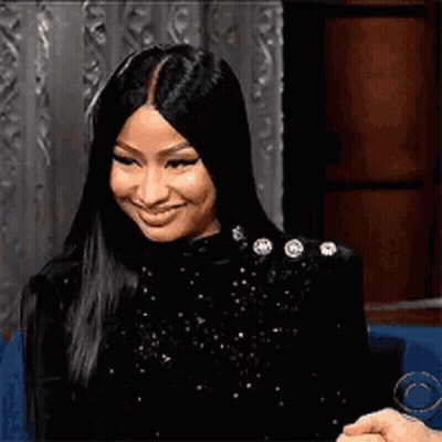 Nicki Minaj Smiling While Sitting In Chair GIF