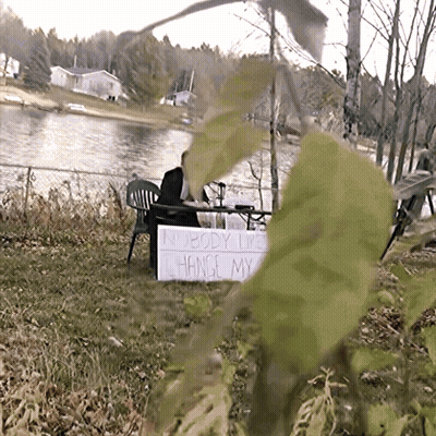 Nobody Likes Change Sign In Front Of Lake GIF