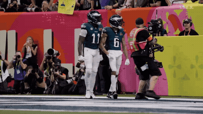 Number 11 Football Player Holding Hands With Teammate GIF