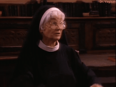 Nun Standing In Front Of Bookshelf GIF