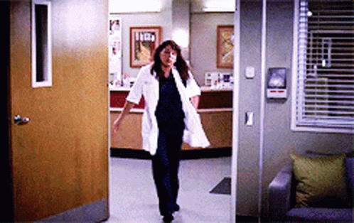 Nurse In Lab Coat Walking Through Doorway GIF