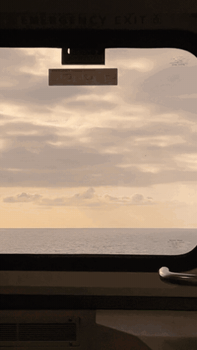 Ocean View Through Window With Emergency Exit Sign GIF