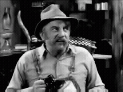 Old Man In Hat And Suspenders Holding Camera GIF