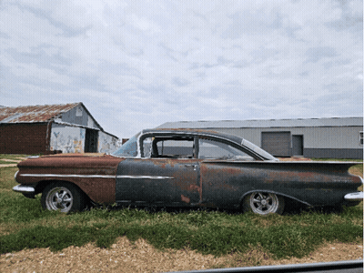 Old Rusty Car Parked in Field With Barn