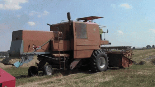 Old Rusty Combine Harvester Parked In Grass GIF