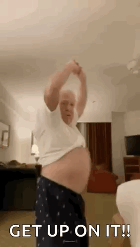 Older Man Dancing In Living Room Holding Arms Up GIF