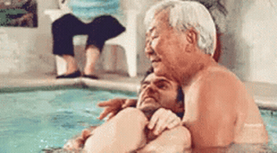 Older Man Hugging Younger Man In Pool GIF