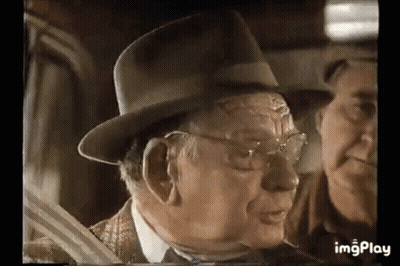 Older Man In Hat Talking To Man In Car GIF