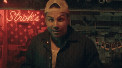 Older Man In Red Shirt Talking To Younger Man In Black Jersey With Valio GIF