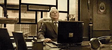 Older Man In Suit Sitting At Desk GIF