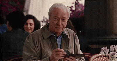 Older Man Sitting At Restaurant Holding Wallet GIF