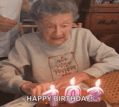 Older Woman Blowing Out Birthday Candles GIF