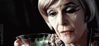 Older Woman Holding Glass Of Green Liquid 2023 GIF