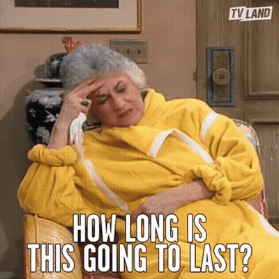 Older Woman In Yellow Robe Sitting Saying How Long Is This Going To Last GIF
