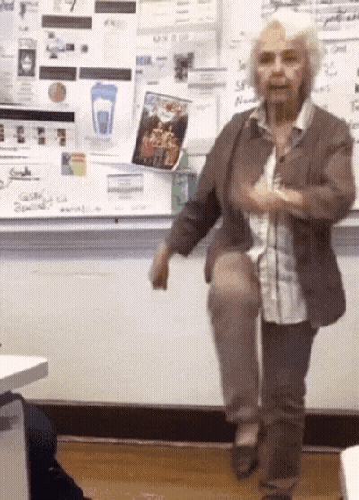 Older Woman On One Leg At Whiteboard With Blue Cup GIF