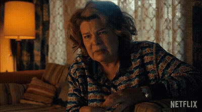 Older Woman Sitting On Couch With Netflix Logo GIF