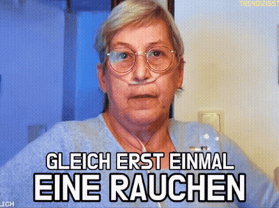 Older Woman With Glasses And Nasal Cannula Saying Glich Erst Einmal Eine Rauchen GIF